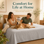A couple and golden retriever relaxing on a light grey Jacquard grounding sheet in a warm bedroom.